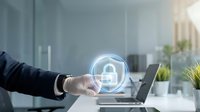 Businessman touching glowing digital padlock shield icon in modern office, representing cybersecurity, data protection, and network safety concept.