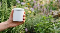 Hand holding white cylindrical container in herb garden with lavender and rosemary plants, suitable for cosmetics, skincare, or natural product packaging mockups.