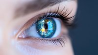 Close-up of bright blue eye with digital network reflection, long eyelashes and technological elements merged with iris, representing future vision and AI concept.