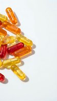 Colorful vitamin capsules and supplements scattered on white background with shadows. Health, wellness and nutrition concept for medical design.
