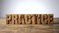 Wooden letter blocks spelling PRACTICE on rustic surface for motivation, education and skill development concepts in business training materials.