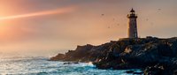 Lighthouse on rocky coastline at sunset with dramatic sky and ocean waves crashing against cliffs. Maritime navigation beacon tower on rugged shore during golden hour.