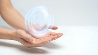 Female hands cupping glowing digital fingerprint hologram representing cybersecurity, biometric authentication and identity protection technology.