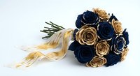 Elegant bridal bouquet with navy blue and gold paper roses tied with cream ribbon on white background for wedding design and romantic decor projects.