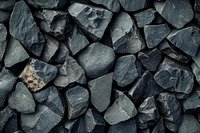 Dark gray slate stone fragments scattered creating natural textured background for construction and landscaping projects.
