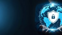 Businessman hands holding glowing digital globe with cybersecurity shield icon representing global data protection and network security solutions.