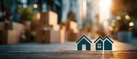 Small wooden house models on table with warm bokeh lights creating cozy real estate investment concept for property development and home buying decisions.
