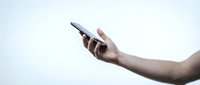 Hand holding smartphone with blank screen against white background, isolated for app mockup and digital technology design use.