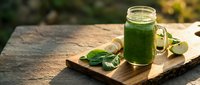 Fresh green smoothie in mason jar on rustic wooden board with spinach leaves, healthy detox drink for wellness lifestyle and nutrition.