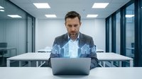 Professional businessman using laptop with holographic house icons in modern office environment for real estate technology and digital property solutions.