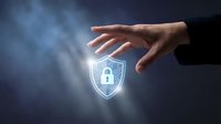 Hand protecting glowing digital security shield with lock icon against dark background representing cybersecurity data protection and privacy.