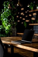 Laptop on wooden desk with floating mail icons above, green plants and pendant lights in background, representing digital communication and email marketing.