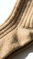 Close-up of a ribbed beige wool sock on a white background, showcasing soft texture and knit detail for fashion and lifestyle use.