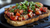 Fresh bruschetta topped with juicy cherry tomatoes, fragrant herbs, and balsamic glaze served on crusty toasted bread against dark background.