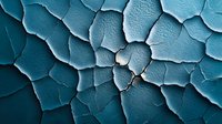 Cracked and peeling paint texture in turquoise blue tones creates abstract pattern of dried fragments on weathered surface, macro photography closeup view.