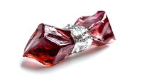 Red crystal fragments with silver foil wrapping on white background, isolated gemstone pieces showing translucent facets and reflective surfaces in studio lighting.