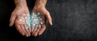 Two hands cupped together with glowing digital network connections and data streams flowing between palms, representing technology transfer, innovation, collaboration, and digital connectivity on dark background.