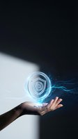 Hand holding glowing digital shield icon with blue light particles and data streams, representing cybersecurity, data protection, and network security technology solutions.