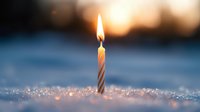 Single lit birthday candle glowing in fresh snow at sunset, creating magical winter celebration atmosphere with bokeh sparkles and warm light glow.
