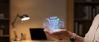 Close-up of hand holding glowing shopping cart hologram with checkout icon, representing digital commerce, online retail technology, and e-commerce solutions for business.