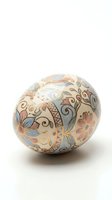 Decorative ceramic sphere with intricate floral patterns and ornate swirls in soft pastel colors isolated on white background for home decor and craft projects.