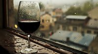 Glass of red wine on windowsill with raindrops on window and blurred cityscape background creating cozy atmospheric mood on rainy day.