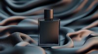 Elegant black glass perfume bottle on luxurious dark silk fabric with soft folds and waves creating dramatic lighting effect for cosmetic advertising.