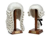 Vintage white curled judicial wig displayed on wooden stand from front and back angles, isolated on white background for costume, theater, legal profession, and historical reenactment design use.