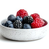 Fresh mixed berries including blueberries, blackberries and raspberries in modern speckled ceramic bowl on white background, close up view for healthy eating concept.