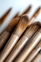 Close-up of traditional wooden paintbrushes with natural bristles, showing fine details and craftsmanship for art and calligraphy applications.