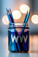 Colorful pencils in glass jar with WWW text against blurred bokeh lights background, creative home office setup for web design and digital marketing concept.