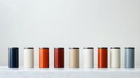 Minimalist arrangement of reusable metal water bottles in different colors aligned in row against white background. Modern eco-friendly lifestyle concept.