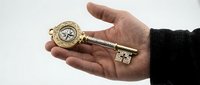 Ornate golden vintage key with compass design held in open palm against white background, symbolizing guidance, discovery and unlocking opportunities.