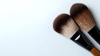 Professional makeup brushes with soft brown bristles and black handles on white background, minimal cosmetic flatlay composition for beauty industry and artistry.