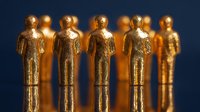 Golden figurines of business people standing in row against dark background, symbolizing leadership, teamwork, and corporate success in business concept.