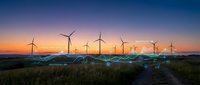 Wind turbines generating renewable energy at sunset with golden sky and green fields creating sustainable power landscape for environmental projects.