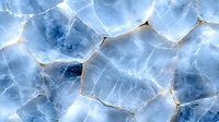 Cracked ice surface with golden veins pattern, abstract winter background in blue and gold tones showing natural frozen texture and crystalline structure.