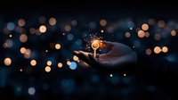 Magical glowing light sphere floating above open palm against dark background with bokeh lights, creating mystical and ethereal atmosphere.