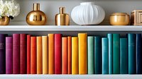 Colorful rainbow collection of books arranged on wooden shelf with decorative gold and white vases, creating modern home library display. Perfect for interior design.
