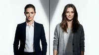 Two professional businesswomen in corporate attire standing against white background for workplace diversity and leadership concepts.
