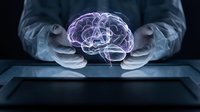 Businessman hands protecting glowing brain hologram with AI symbol representing artificial intelligence technology and machine learning innovation.