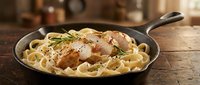 Delicious chicken and pasta dish served in cast iron skillet on rustic wooden table. Comfort food meal with herbs and cheese for restaurant menu design.