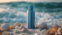 Reusable metal water bottle on beach sand with seashells and ocean waves in background creating serene coastal wellness scene at sunset.