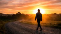 Silhouetted runner jogging on rural dirt road at golden sunrise with warm glowing sky and misty landscape, suitable for fitness, motivation, and wellness marketing.