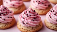 Delicious pink frosted cupcakes with chocolate sprinkles on golden bases, perfect for bakery displays, dessert menus, and sweet celebration marketing materials.