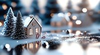 Miniature winter scene with glowing house and snow-covered pine trees against blurred bokeh lights background, creating magical holiday atmosphere.