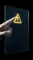 Hand touching digital screen displaying glowing yellow warning alert symbol on dark circuit board interface background for cybersecurity and system alerts.
