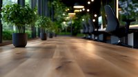 Polished wooden table surface in modern office space with decorative plant and ambient lighting creates professional atmosphere for business meetings.