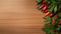 Fresh red chili peppers and green bay leaves create decorative border on wooden cutting board background, with copy space for food photography.