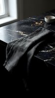 Dark marble countertop styled with charcoal linen napkin, ceramic bowl, and natural window light for modern kitchen and home decor design projects.